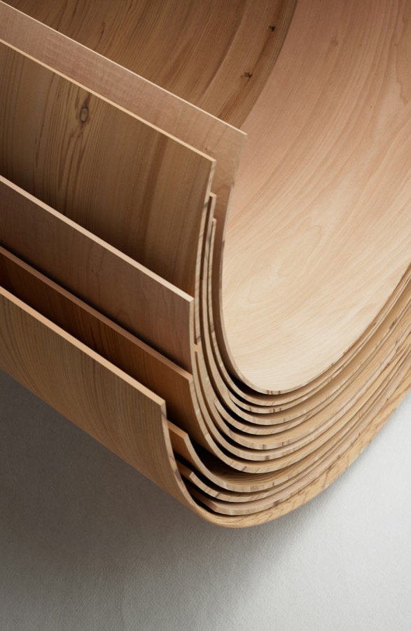 Thin sheets of timber veneer, curved and stacked.